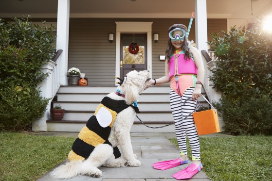 Littel girl and a dog dressed up