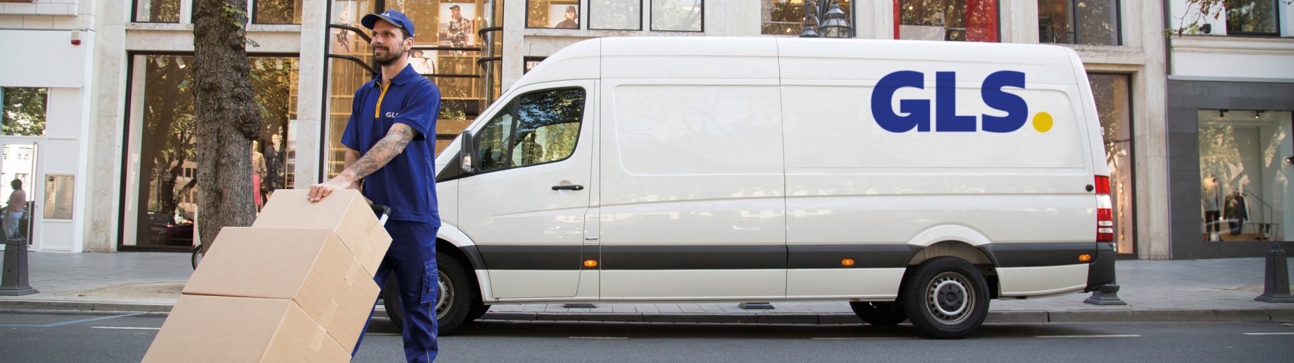 GLS delivery driver handling parcels in front of a GLS van in a city center, representing GLS France’s nationwide delivery network.