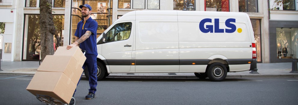 GLS delivery driver handling parcels in front of a GLS van in a city center, representing GLS France’s nationwide delivery network.