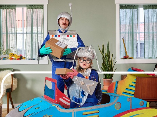 Father and son playing with toys made out of boxes