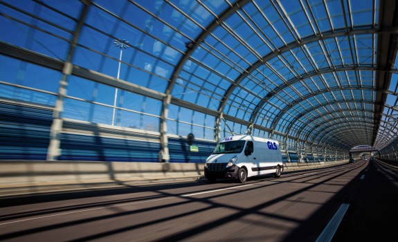 A GLS van is driving through a covered bridge